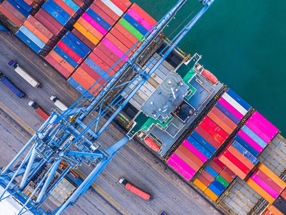Overhead view of dock crane unloading containers from a cargo ship