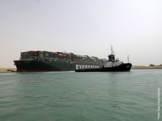 Loaded container ship and tug boat in canal